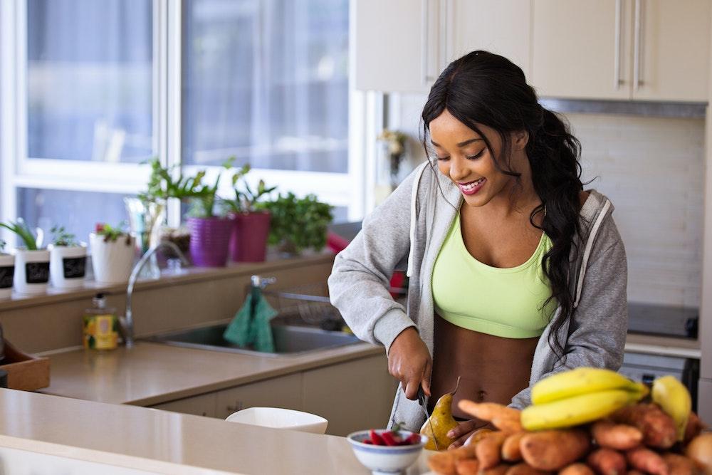Woman cutting fruit while on Rescue detox to cleanse body