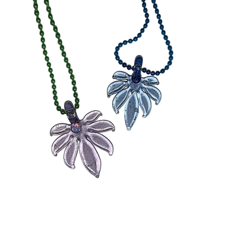 two miniature glass leaves with a white background