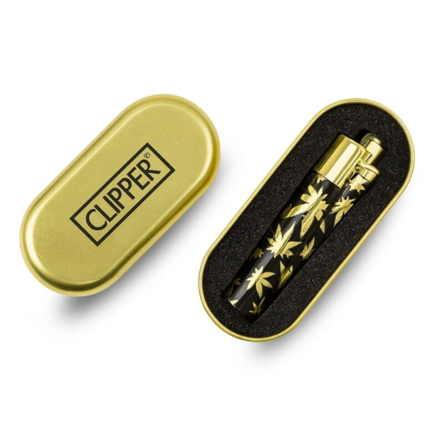 a small golden clipper lighter with a leaf pattern on a white background