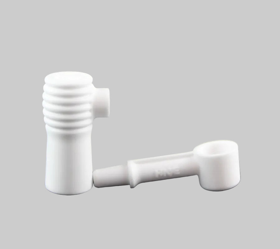 A small ceramic banger separated into two pieces on a white background