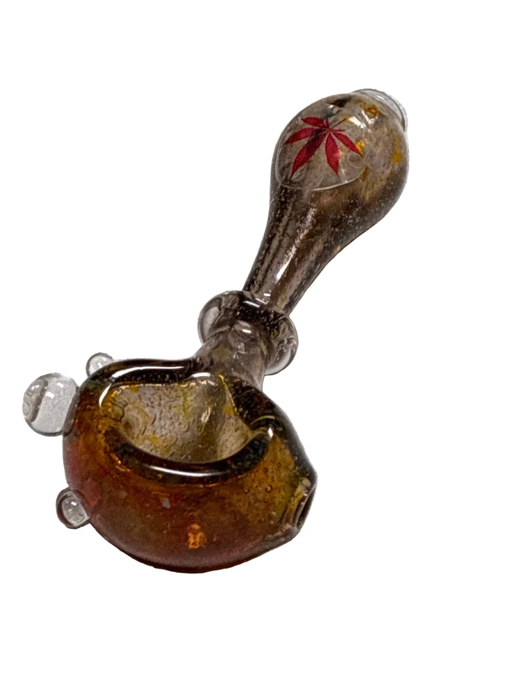 Glass pipe with amber base and red leaf design on a white background