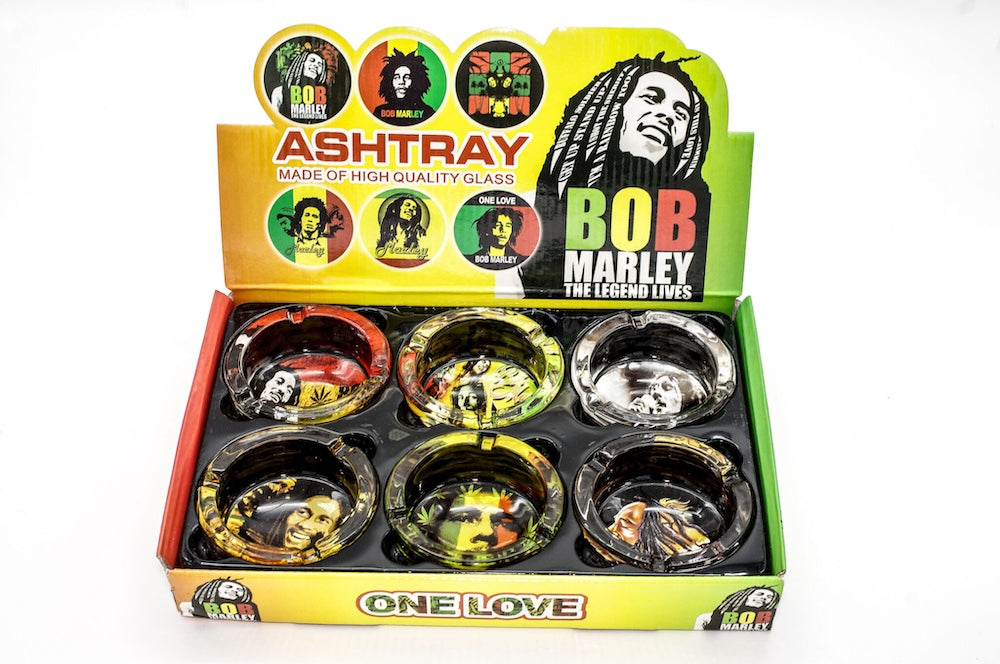 Bob Marley-themed ashtrays in a display box with colorful labels.