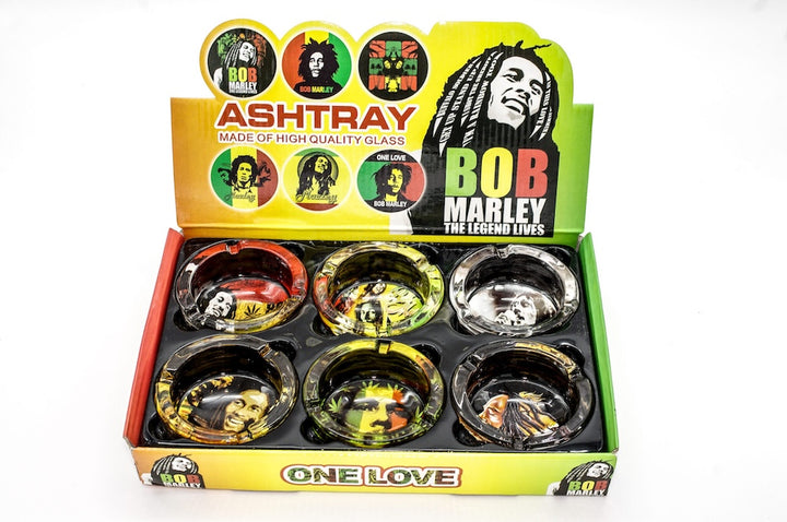Bob Marley-themed ashtrays in a display box with colorful labels.