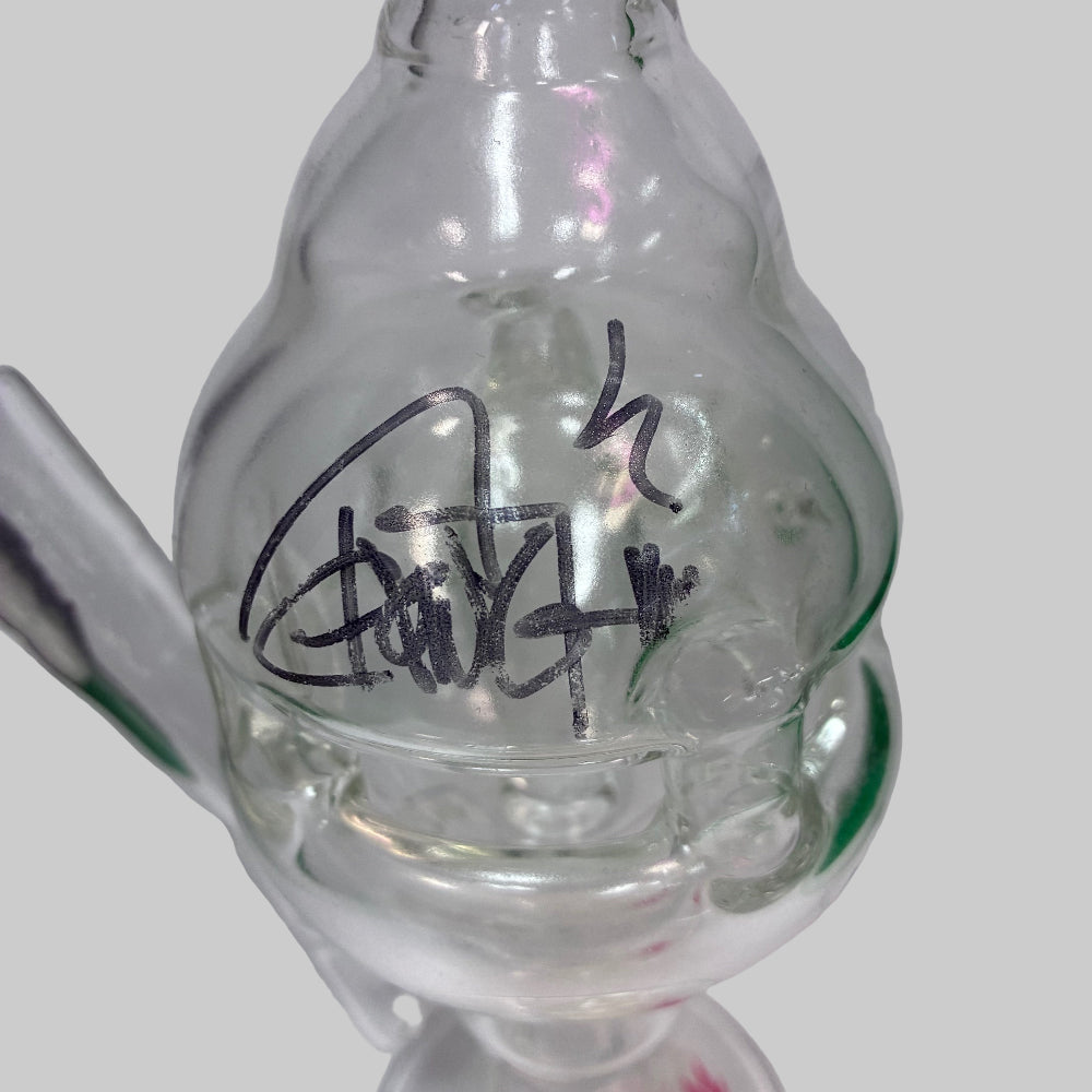 Clear glass water pipe with tommy chong signature on a white background