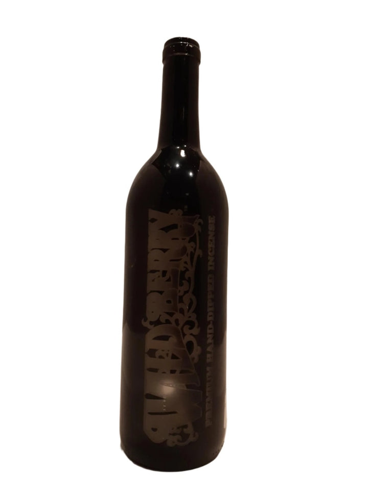 Dark wine bottle incense burner with visible label on a white background