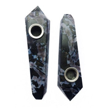 Two black marble-like pipes with circular openings on a white background