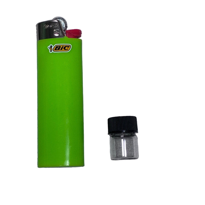 Green BIC lighter with a small glass vial on a gray background