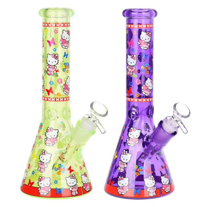 Two glass bongs, one green and one purple, with Hello Kitty designs on a white background.