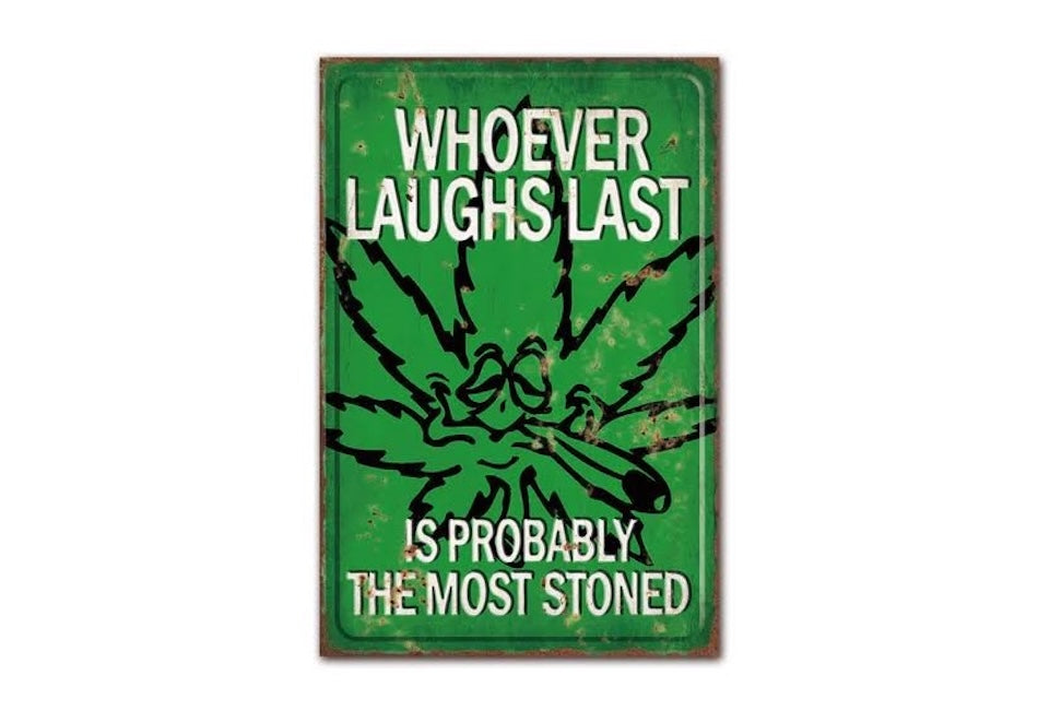 Metal sign with marijuana leaf and text 'Whoever laughs last is probably the most stoned' on a green background.