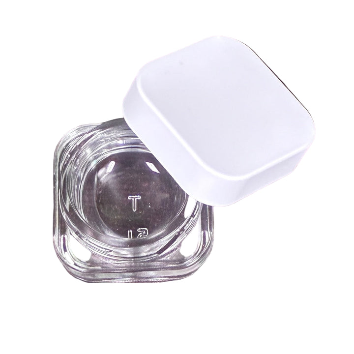 Clear glass container with a white lid on a white surface