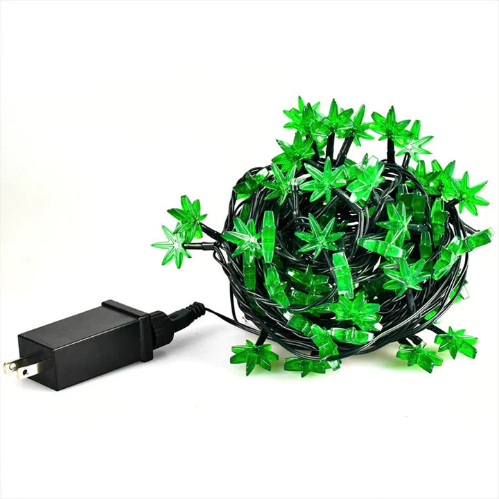 Green string lights with marijuana leaf-shaped bulbs and a black power adapter on a white background