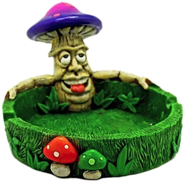 Mushroom-shaped figurine with a face on a green base with mushrooms, on a white background
