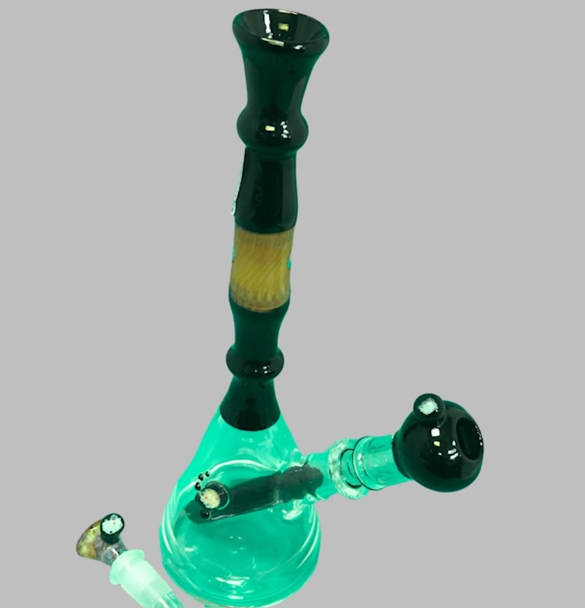 Green and clear glass smoking device on a gray background