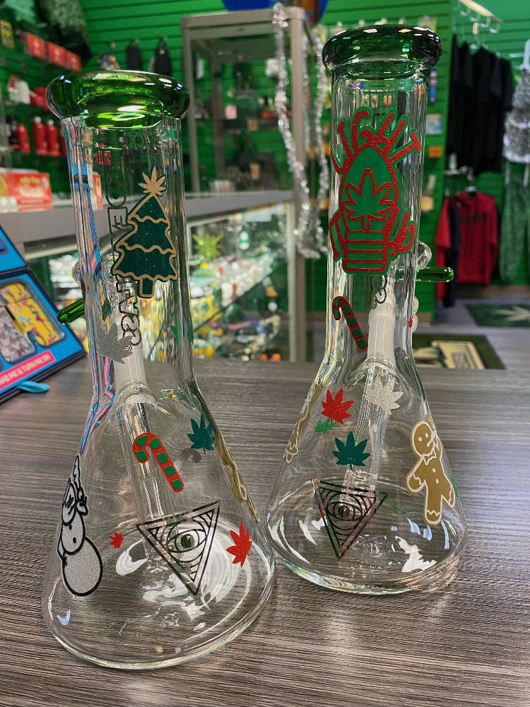 Two glass smoking accessories with decorative designs on a wooden surface.