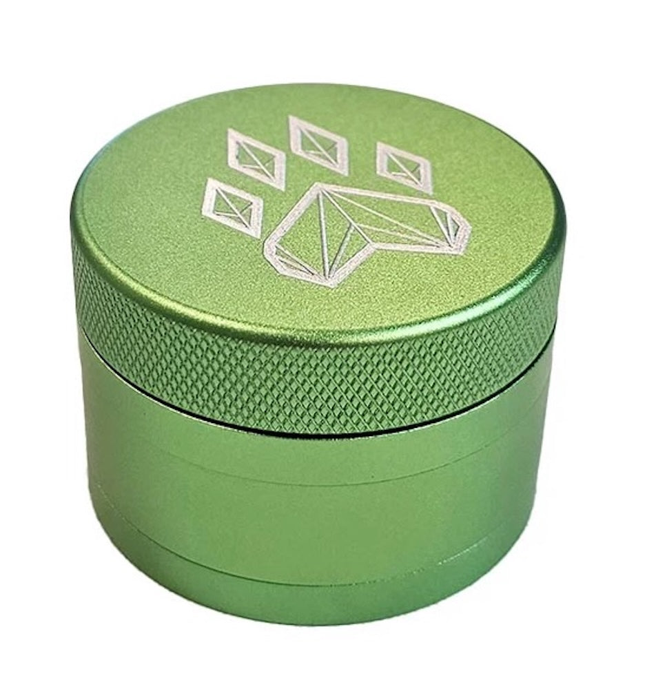 Green metal grinder with a geometric design on a white background