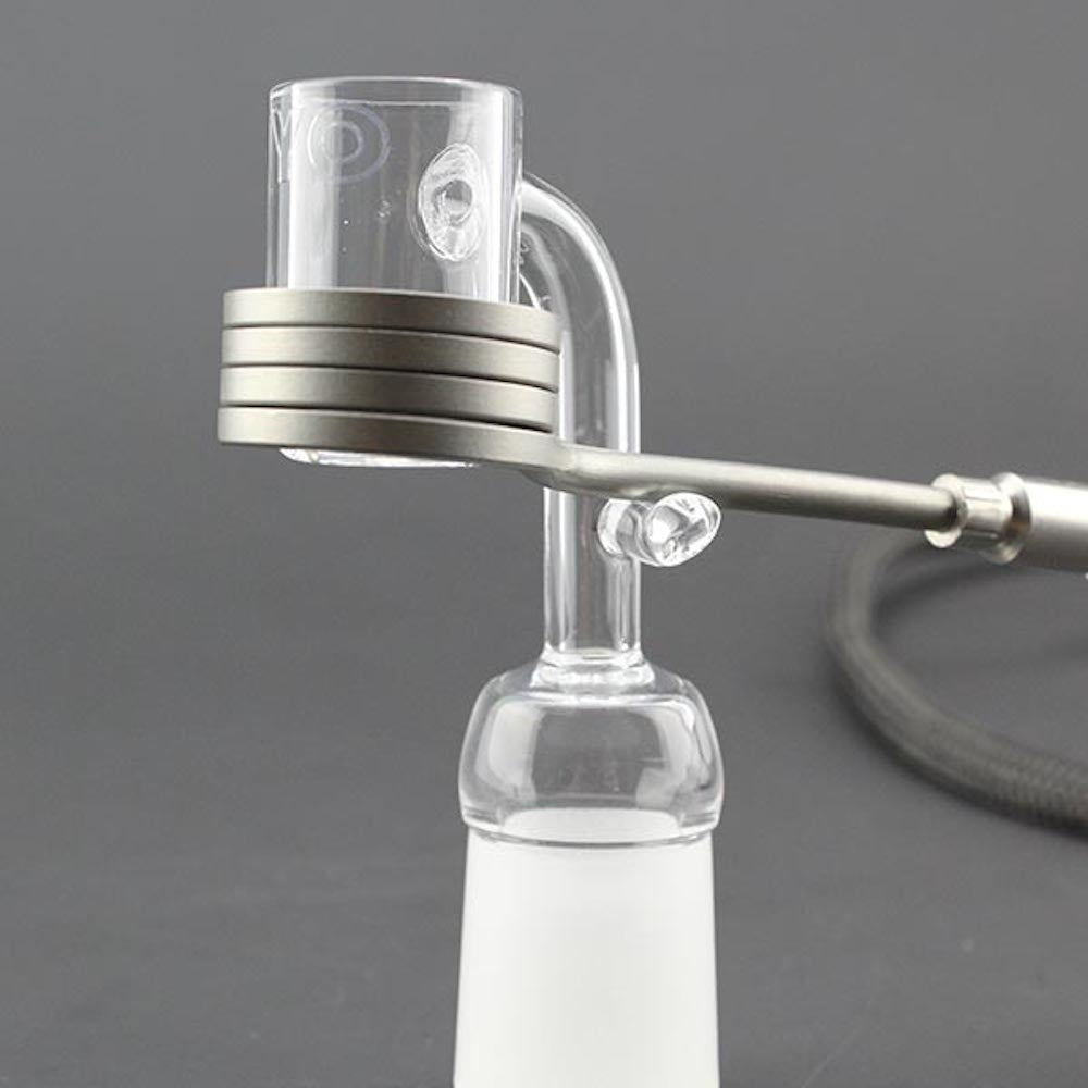 Glass smoking device with metal accents on a gray background